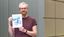 Dr. Matthias Bruhn hält das von ihm gestaltete Titelbild in die Kamera
